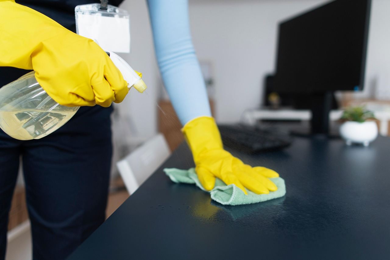 Technician disinfecting an office desk surface