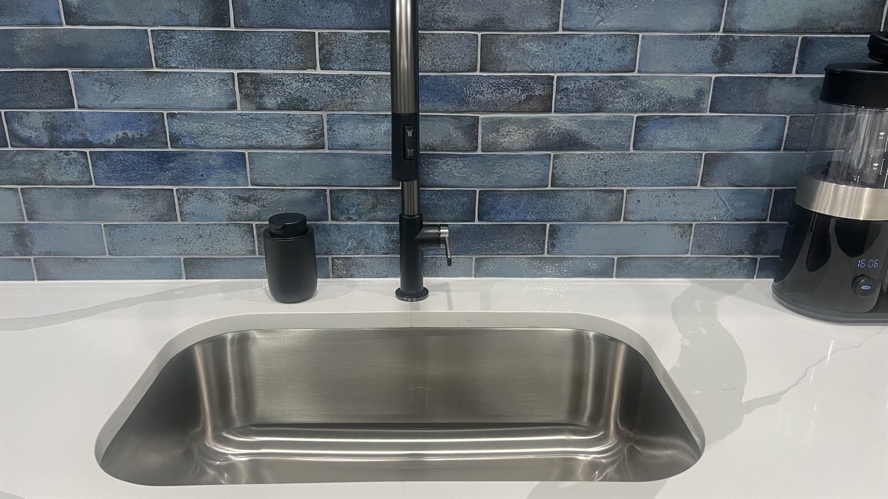 Spotless commercial kitchen sink and blue tile backsplash cleaned by ICS
